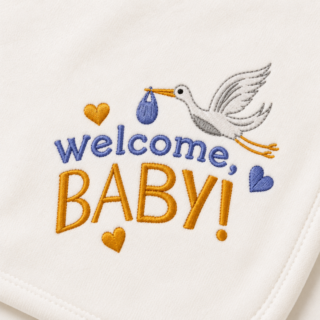 Close-up of the "Welcome, Baby!" stork embroidery detail on an organic baby blanket in blue and gold thread