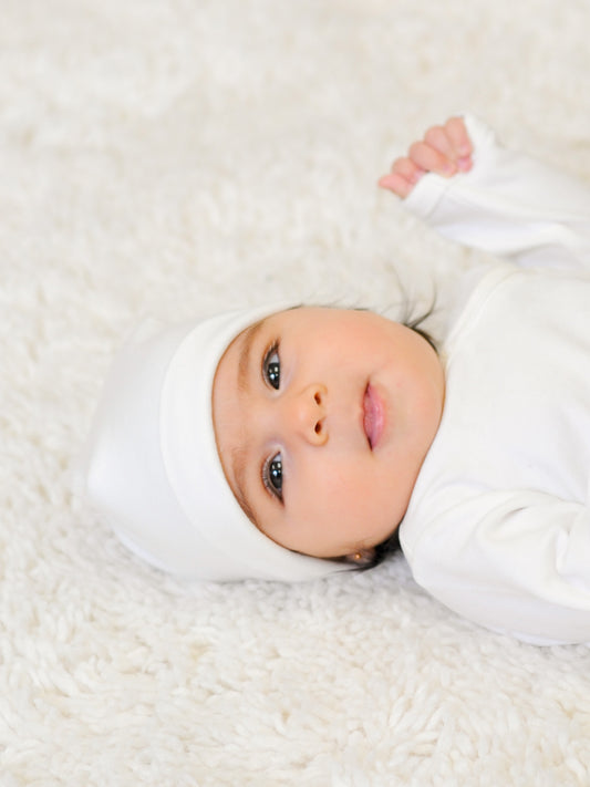 A Baby wearing Prima Cotton’s Organic Baby Hat for Sensitive Skin made from 100% GOTS-certified organic Egyptian cotton.